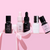 A row of liquid bottles with a baby pink bow looped around some bottles.
